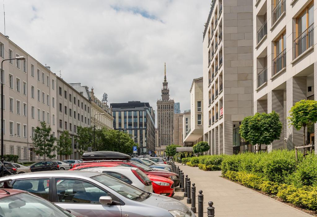 uma fila de carros estacionados numa rua da cidade em P&O Apartments Górskiego em Varsóvia