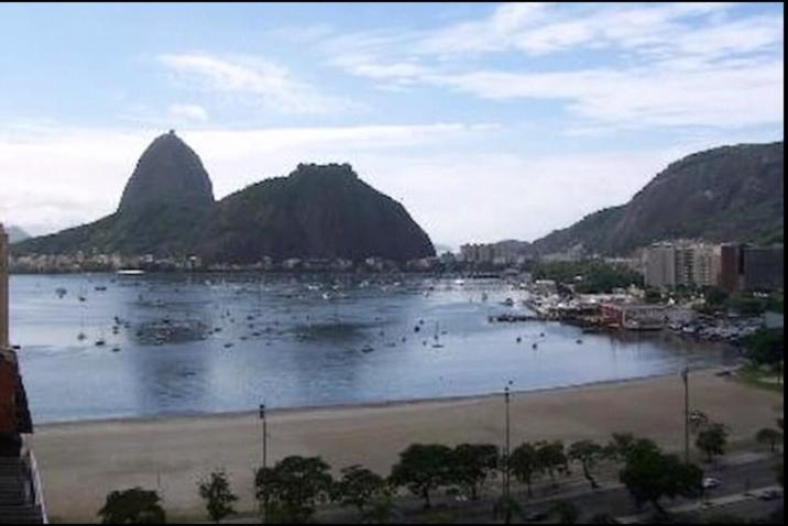 een grote hoeveelheid water met een strand en bergen bij Penthouse Botafogo Rio de Janeiro in Rio de Janeiro