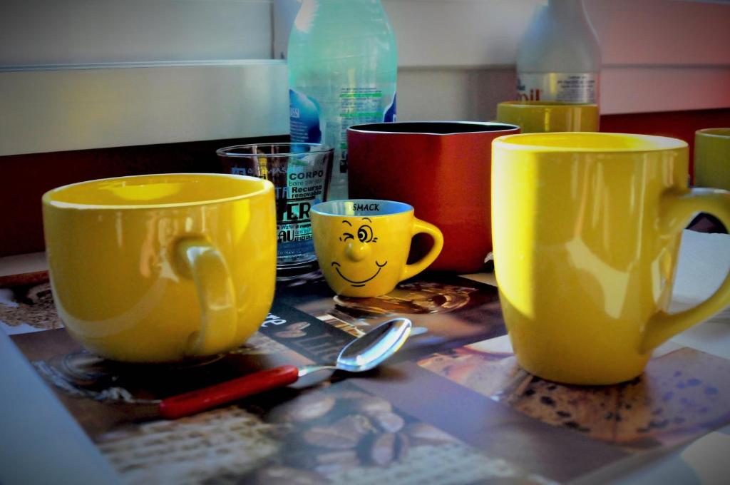 deux tasses jaunes sur une table avec une cuillère dans l'établissement World Wide Bed - Rome, à Rome