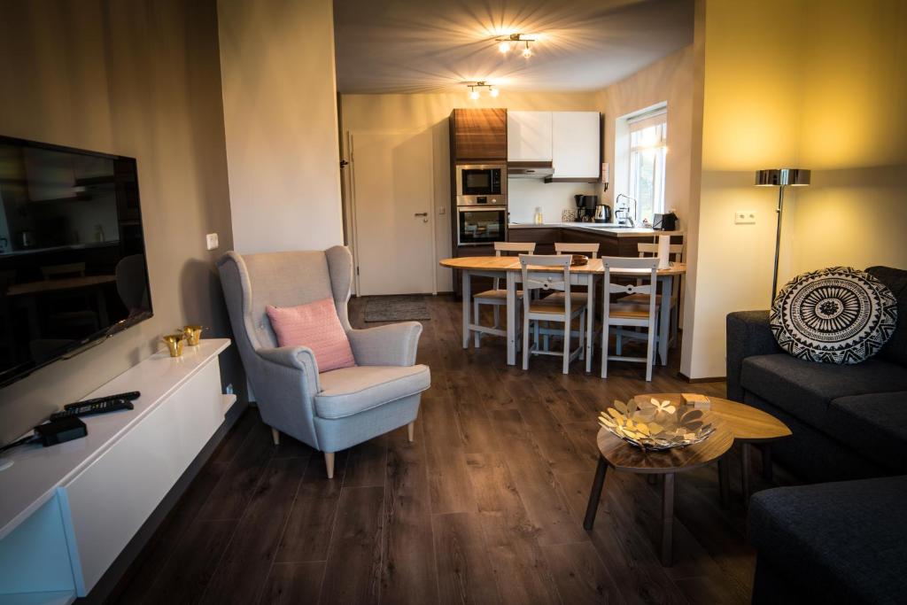 Breidamyri Farm Apartments في لاوغار: غرفة معيشة مع أريكة وغرفة طعام