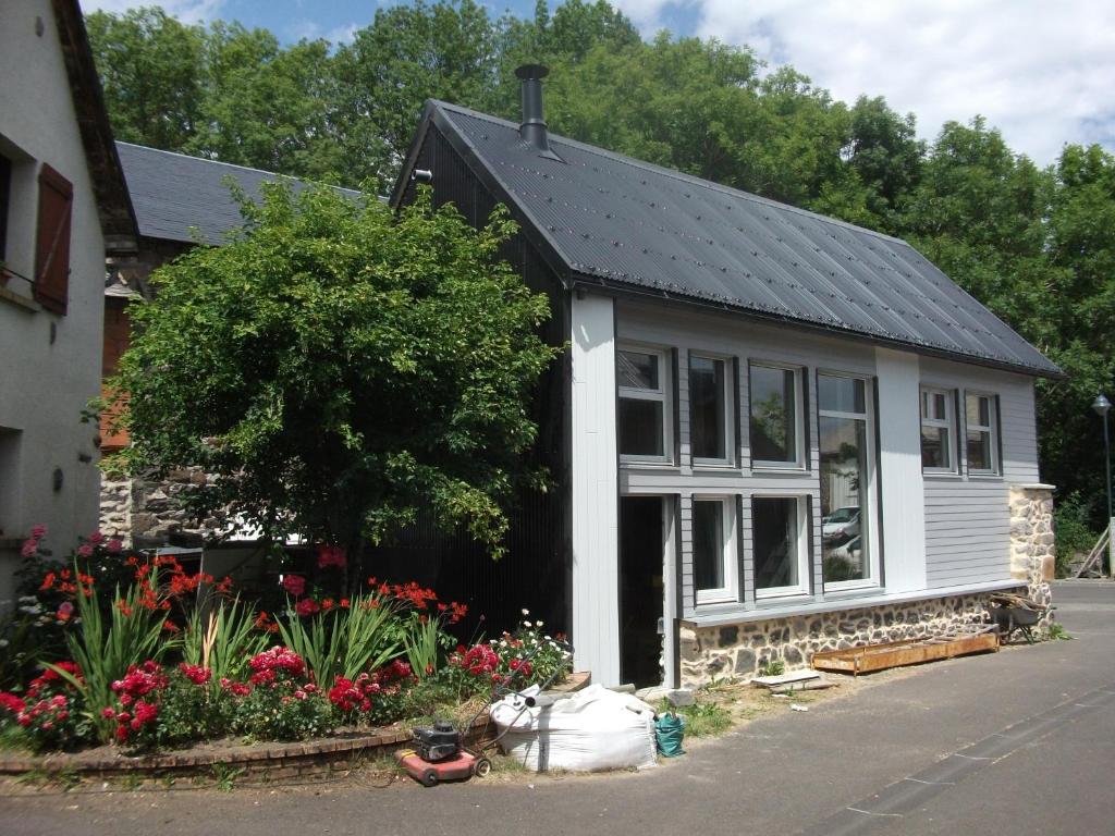 une petite maison blanche avec des fleurs devant elle dans l'établissement Gîte très lumineux, à Vernines