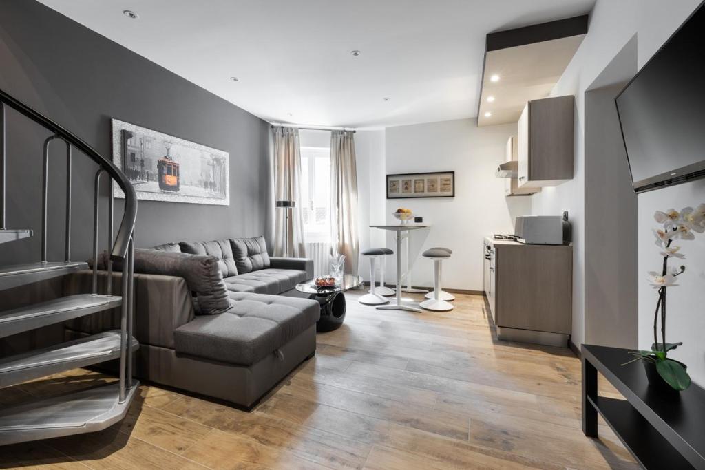 uma sala de estar com um sofá e uma mesa em Leonardo Duplex Apartment em Milão