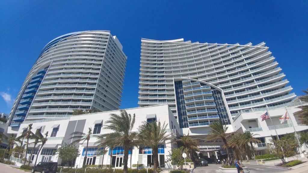 two tall buildings with palm trees in front of them at 2 BR W Residences Ft. Lauderdale in Fort Lauderdale