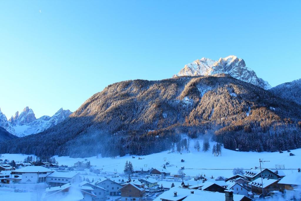 a mountain in the distance with a village in the snow at Hotel Willy in Sesto
