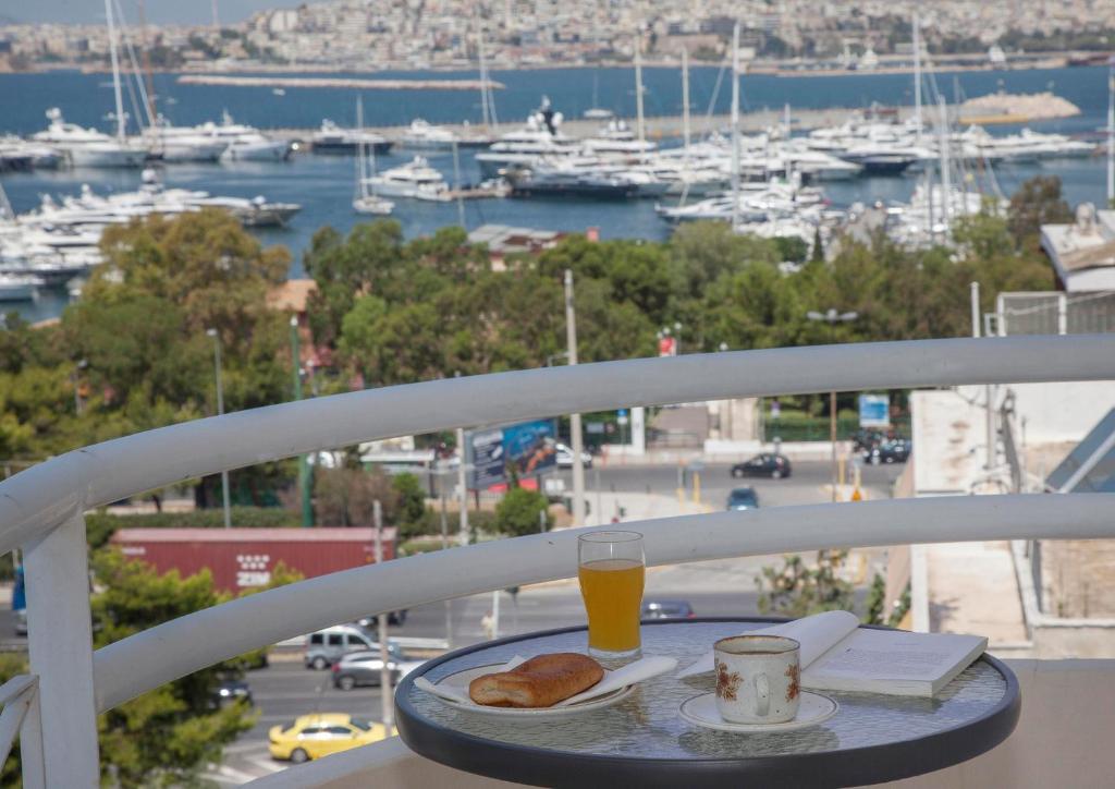 una mesa con un plato de comida y un vaso de zumo de naranja en Nice Sea View Elegant Apartment, en Atenas