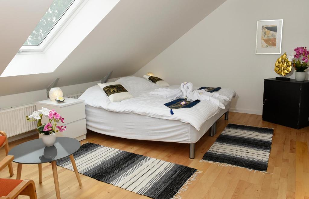 - une petite chambre mansardée avec un lit blanc dans l'établissement Dadas Bed & Breakfast, à Store Heddinge