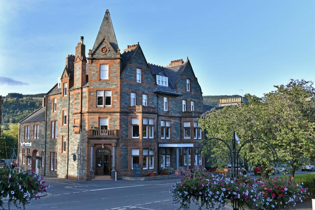 a large brick building with a clock tower on it at The Townhouse Aberfeldy in Aberfeldy