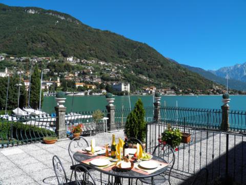 a table and chairs with a view of the water at Casa Re in Gravedona