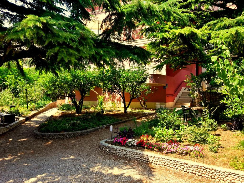 un jardin avec des fleurs et des arbres devant un bâtiment dans l'établissement Villa Libe, à Baška Voda