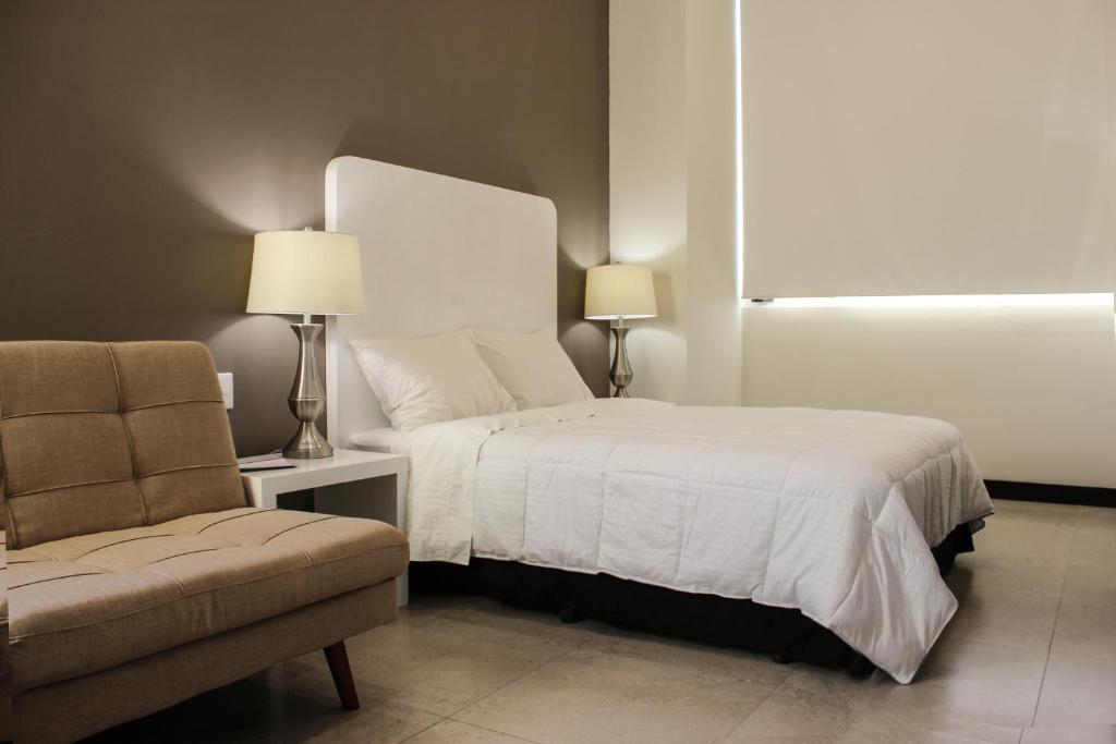 una camera con letto, divano e sedia di Laviu B&B Luxe Suites a Puebla