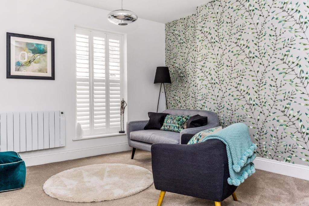 uma sala de estar com um sofá e uma cadeira em 3, Gainsborough House em Cheltenham