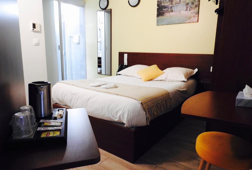 sypialnia z łóżkiem z lustrem i stołem w obiekcie Massilia hôtel w Marsylii