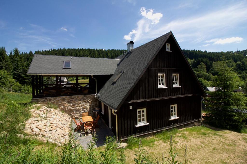 ein schwarzes Haus mit einem Gameradach in der Unterkunft Ferienhaus Anno Dazumal, wie zu Opa`s Zeiten in Klingenthal