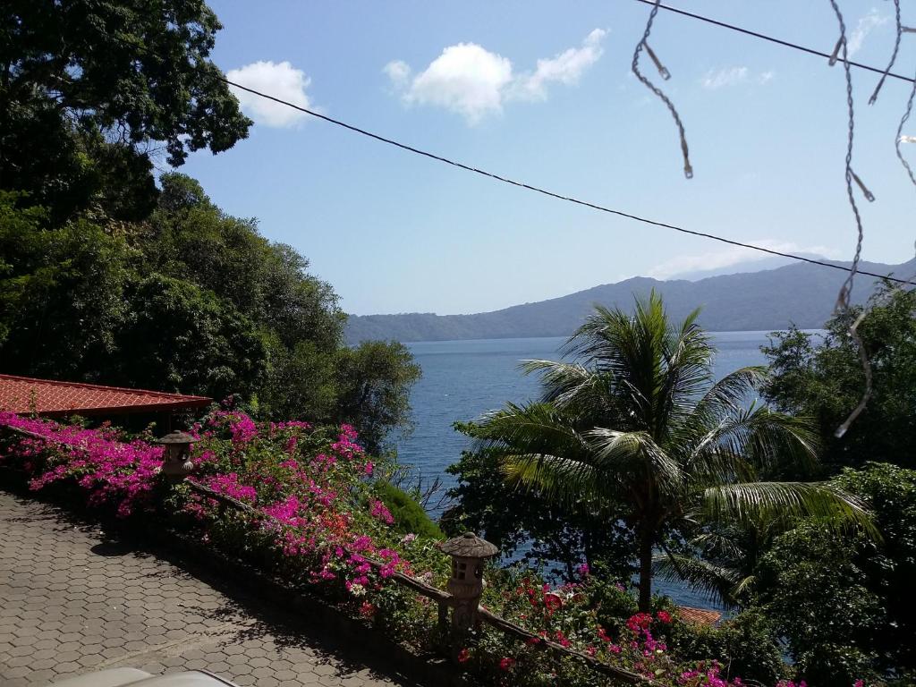 a walkway with flowers and a view of the water at Posada Ecologica La Abuela in La Laguna