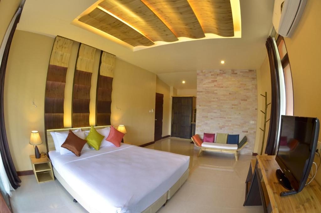 a bedroom with a large bed and a tv at Palm Leaf Resort Koh Tao in Ko Tao