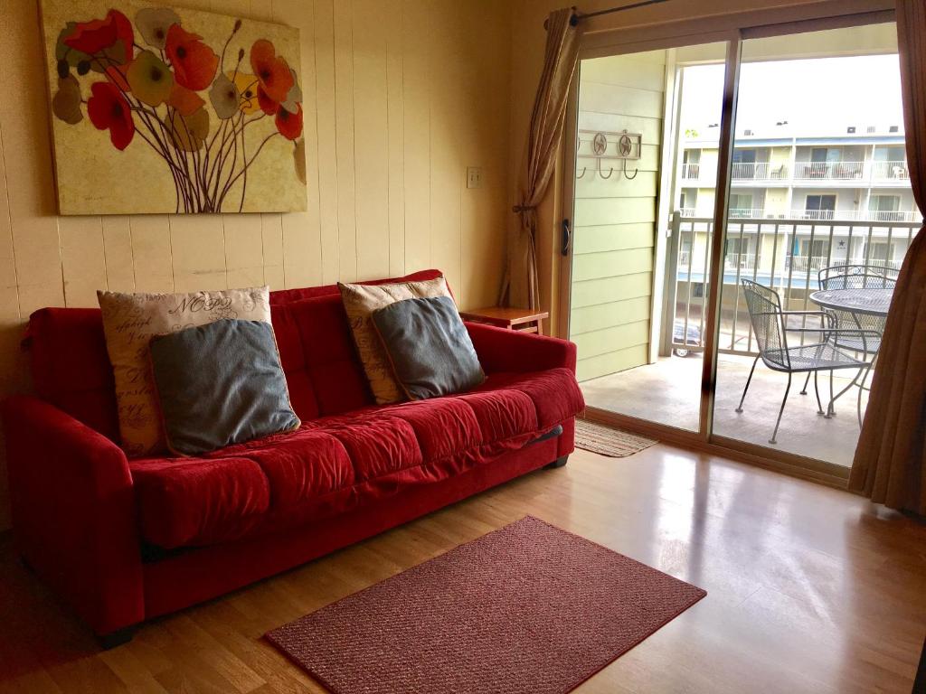 a red couch with pillows in a living room at River Run Retreat in New Braunfels