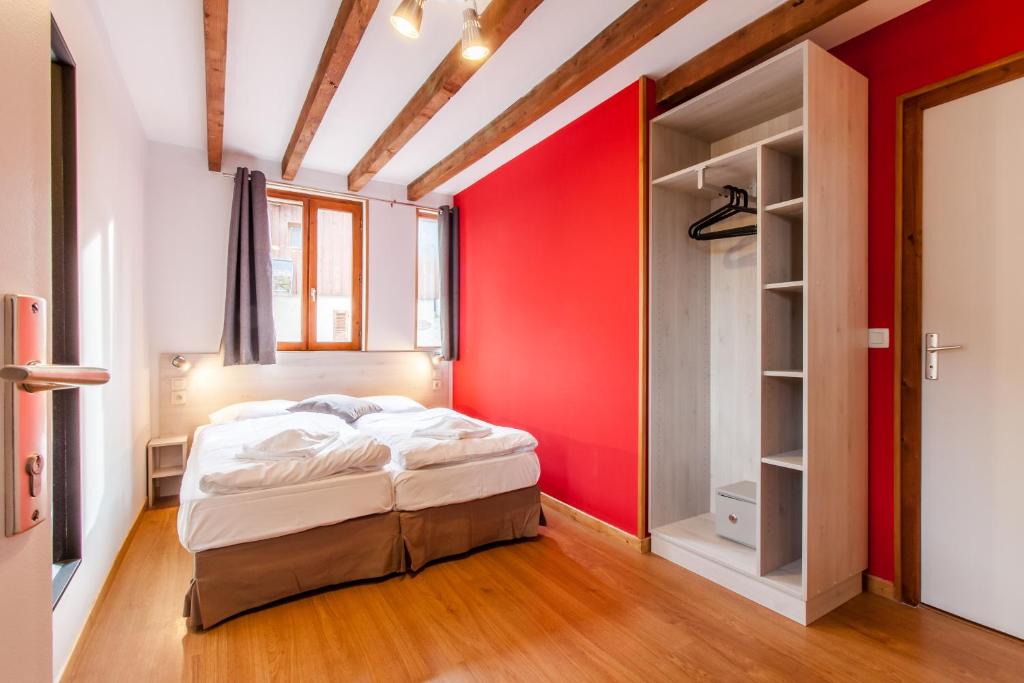 ヴァルモレルにあるホテル シャレー デュ クレイの赤い壁のベッドルーム1室(ベッド1台付)