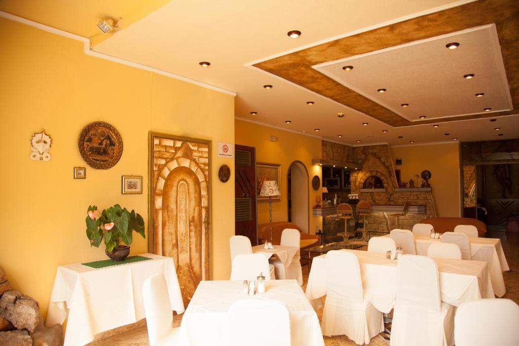 a dining room with white tables and white chairs at Galini Palace in Athens