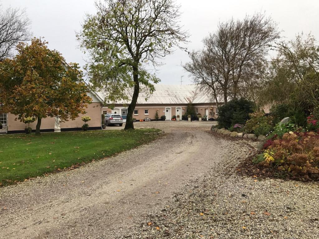 a house with a gravel driveway in front of a house at Klitgaards Holiday Apartment in Mejeriby
