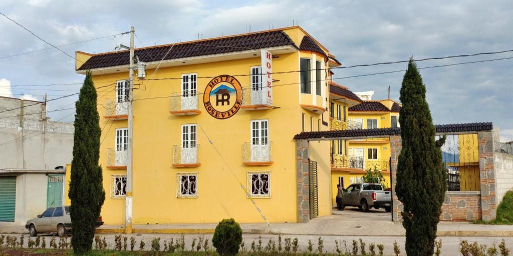 a yellow building with a clock on it at Hotel Roseville in Chignahuapan