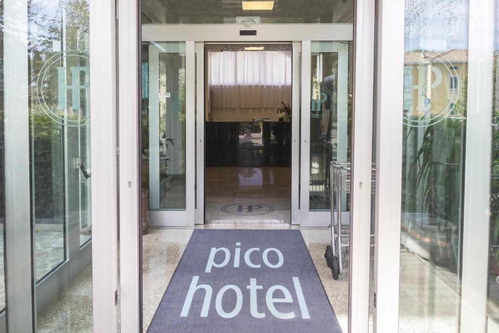 una porta scorrevole in vetro con un cartello dell'hotel per la pizza; di Hotel Pico a Mirandola