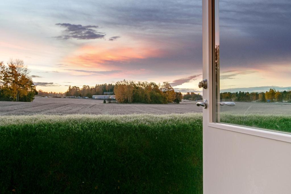 eine offene Tür mit Blick auf ein leeres Feld in der Unterkunft Turinge Hotel in Södertälje