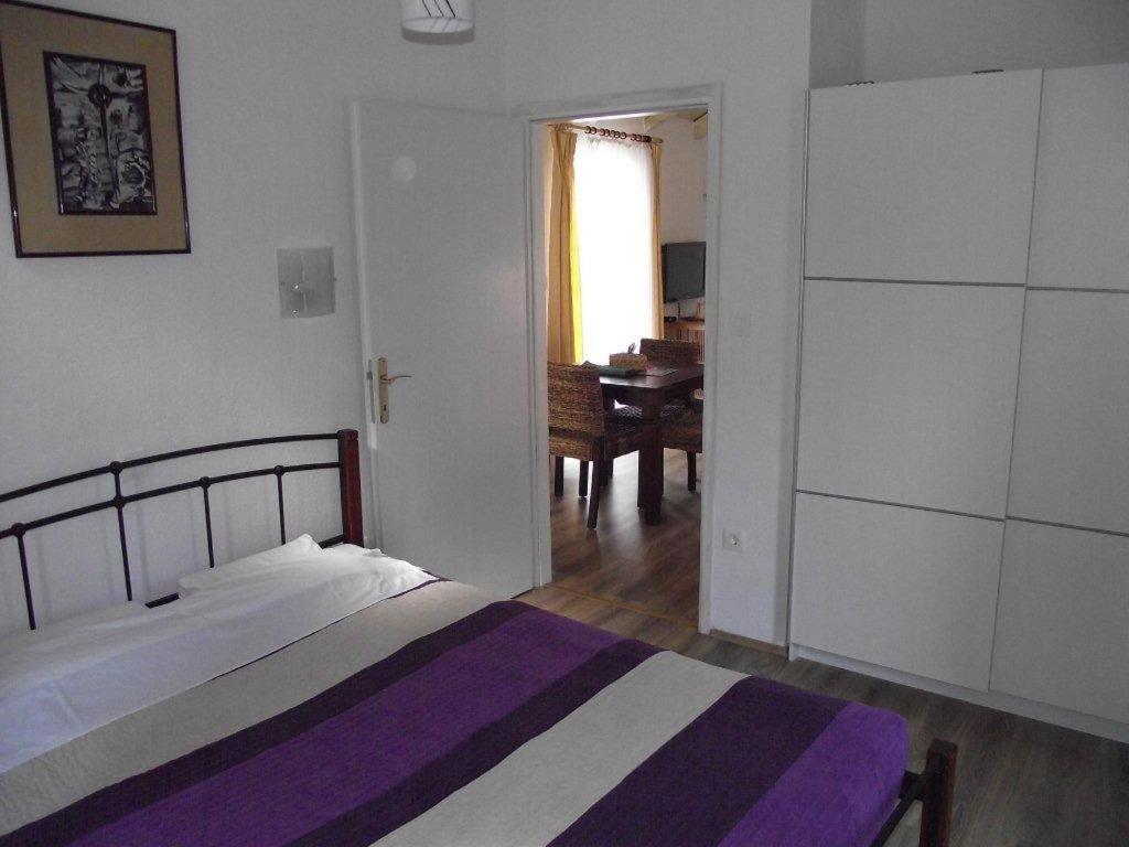 - une chambre avec un lit et une salle à manger dans l'établissement Apartments Dobrinj, à Dobrinj