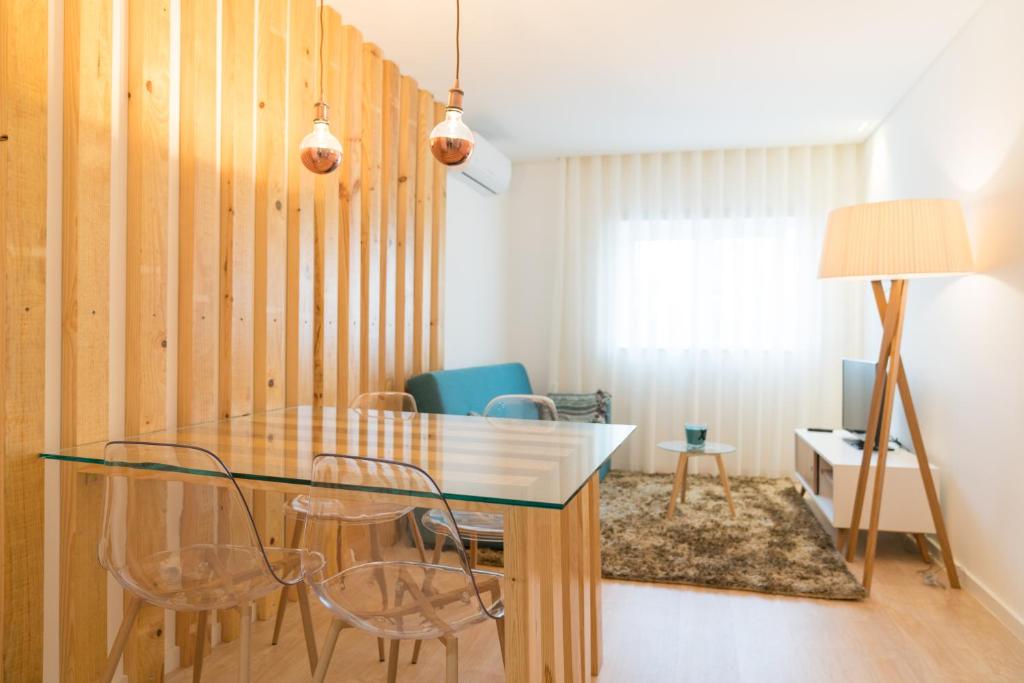 a dining room with a glass table and chairs at Bracara Guest House "D. Pedro V" in Braga