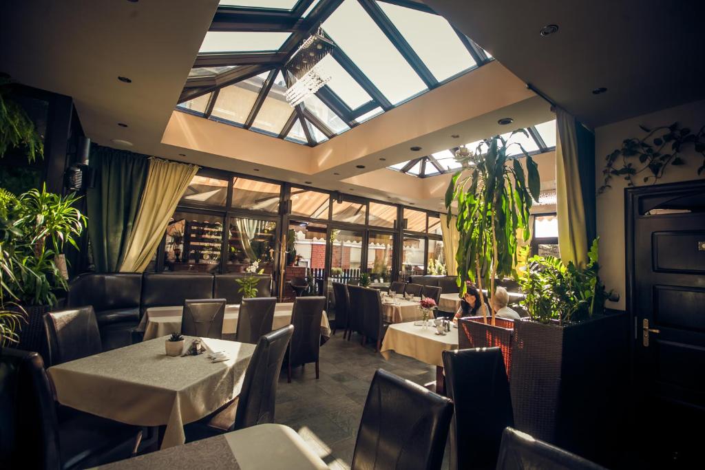 een restaurant met tafels, stoelen en ramen bij Villa Garden Kutno Centrum in Kutno