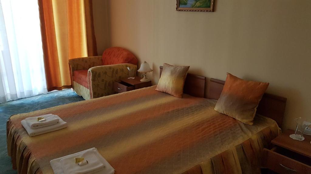 une chambre d'hôtel avec un lit et une chaise dans l'établissement Hotel Venecia, à Primorsko