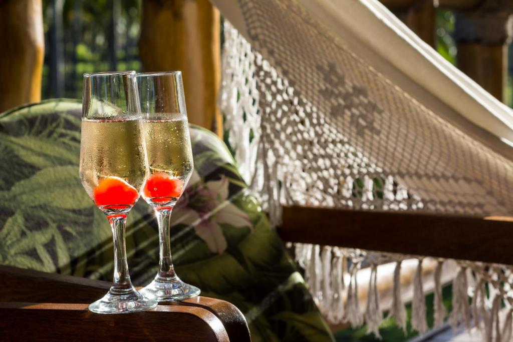 two glasses of champagne sitting on a bench at Villa dos Corais in Morro de São Paulo