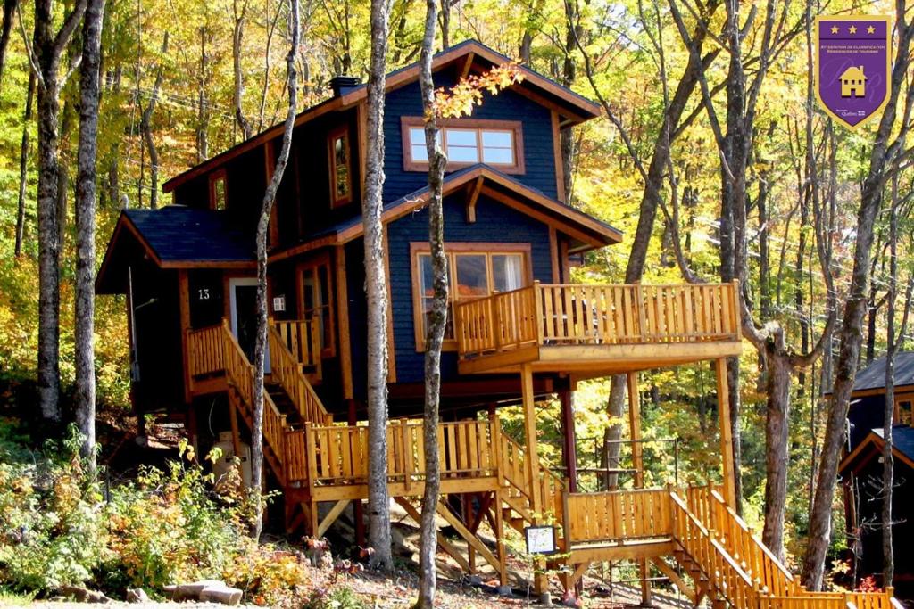 a tree house in the woods with a deck at Chalets Alpins 13 Chemin Alpin in Stoneham