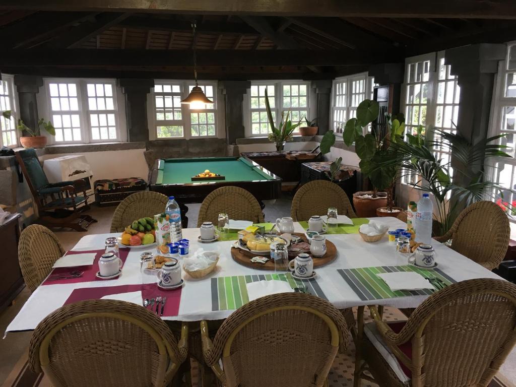 uma sala de jantar com uma mesa e uma mesa de bilhar em Quinta do Rossio, Rural Tourism em Biscoitos