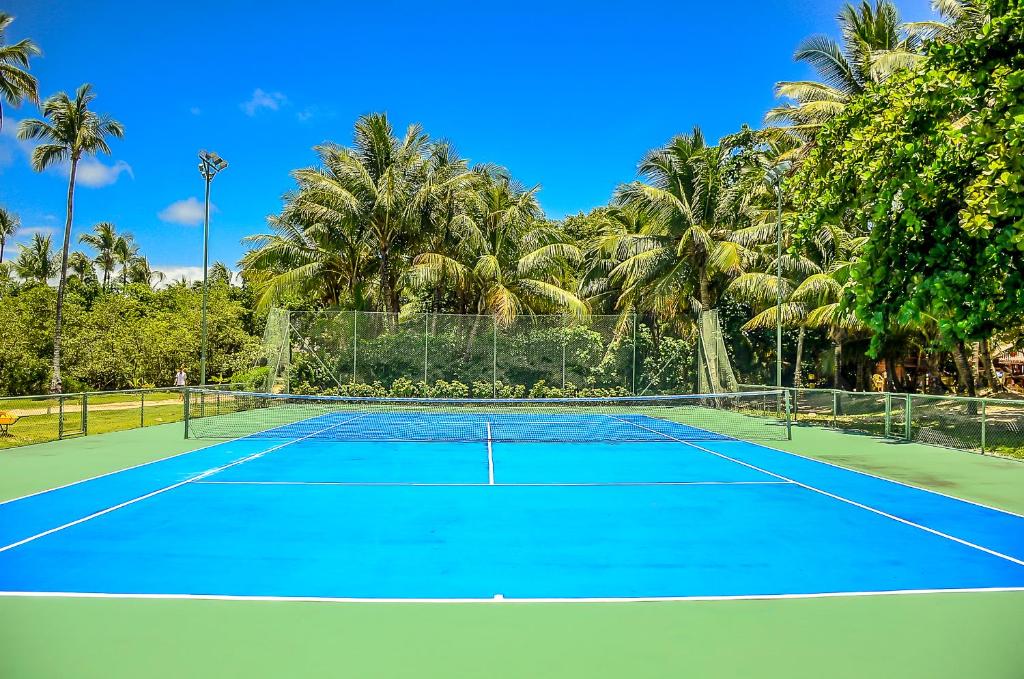 a tennis court with palm trees in the background at Villa dos Corais in Morro de São Paulo