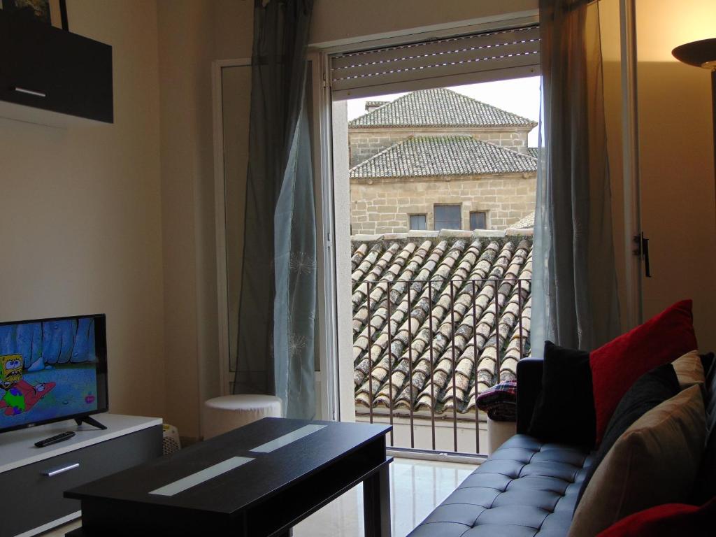 una sala de estar con una ventana con vistas a un edificio en Vivienda Turistica Bufer, en Úbeda