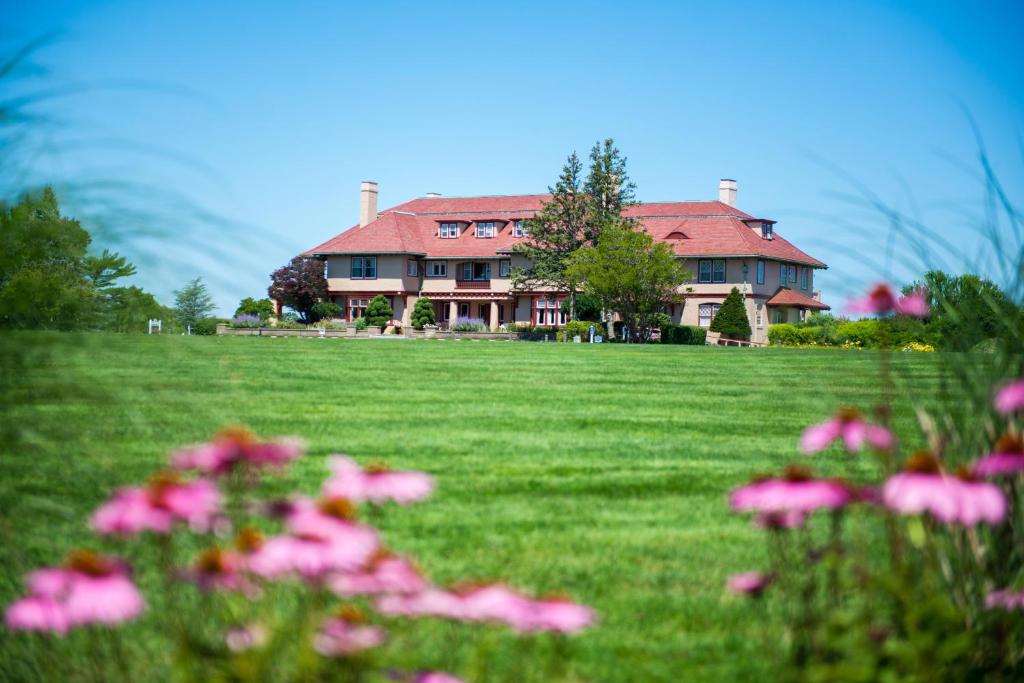 The Mansion at Ocean Edge Resort & Golf Club في بروستر: أمامه بيت كبير وورد وردي