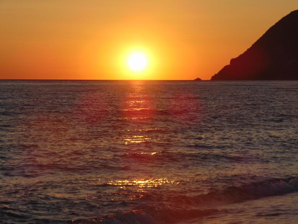 a sunset over the ocean with the sun setting at Apollon (ex. Albatros) in Plomari