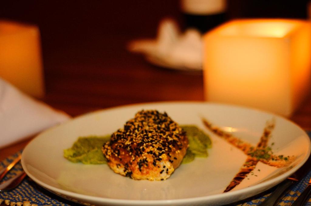 a white plate with a piece of food on a table at Villa dos Corais in Morro de São Paulo