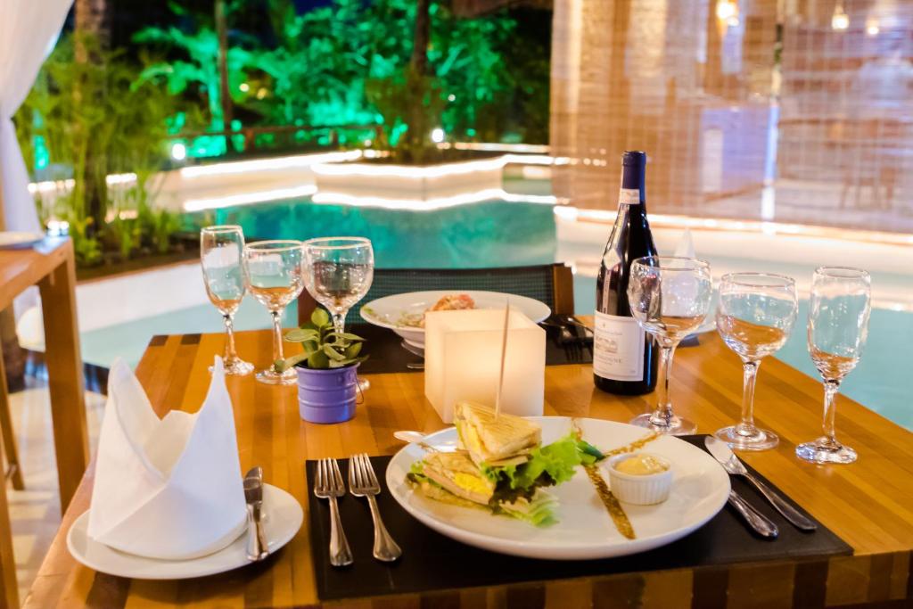 a table with a plate of food and a bottle of wine at Villa dos Corais in Morro de São Paulo