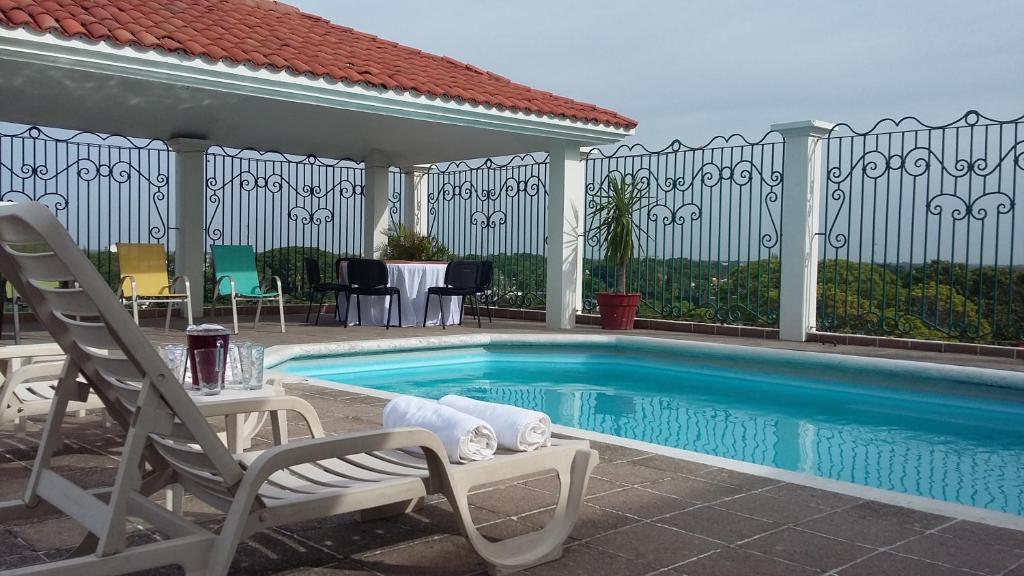 - une piscine avec 2 chaises et une table dans l'établissement Hotel & Suites Real del Lago, à Villahermosa