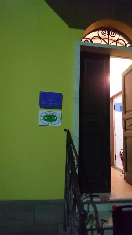 a room with a green wall with a black door at La Divina in Muggiano