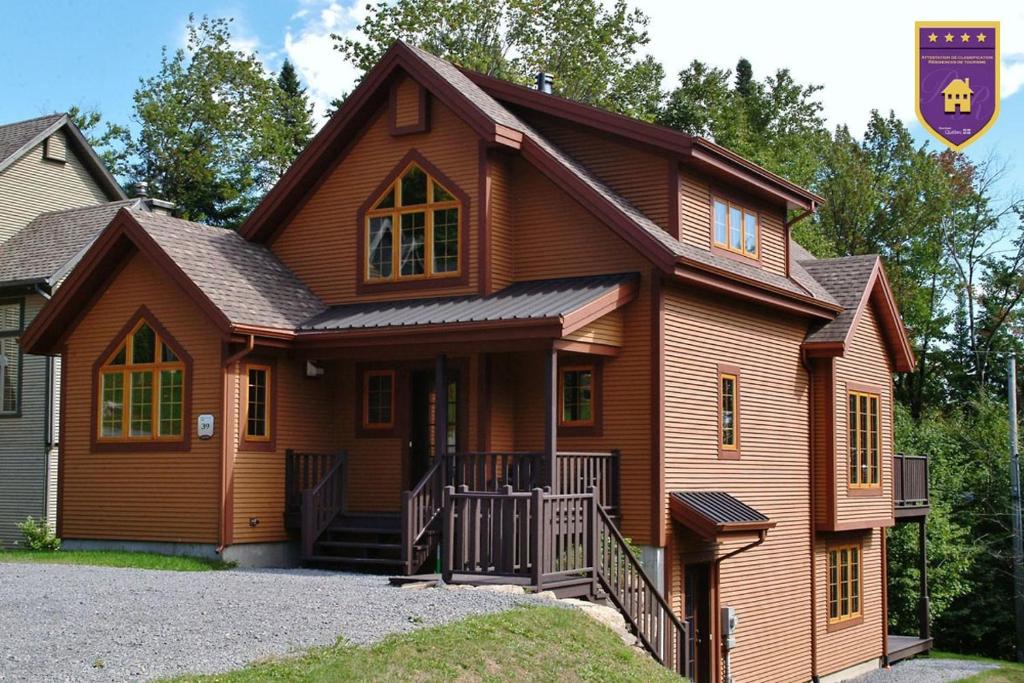a wooden house with a gambrel roof at Chalets Alpins- 39 Chemin des Skieurs in Stoneham