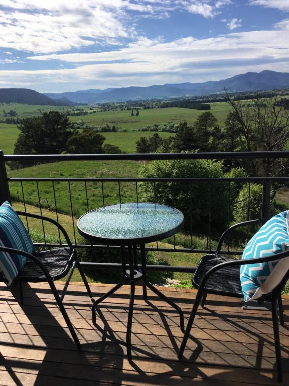 a table and two chairs on a balcony with a view at Rosewhite House in Myrtleford