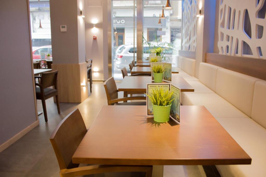 a row of tables in a restaurant with plants on them at Hotel Gran Via in Zaragoza