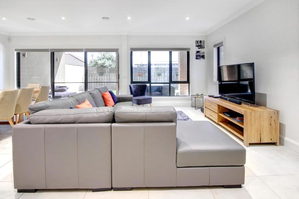 ein Wohnzimmer mit einem Sofa und einem TV in der Unterkunft Sullivan's Retreat in Rye