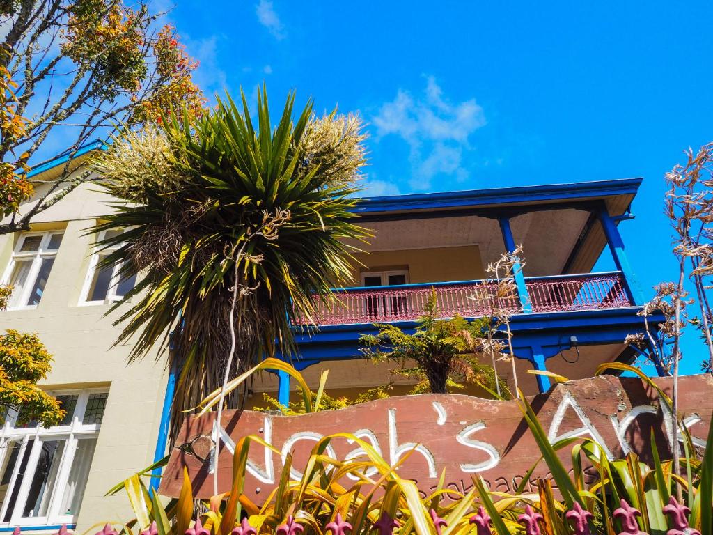 a building with a palm tree in front of it at Noah's Ark Backpackers in Greymouth