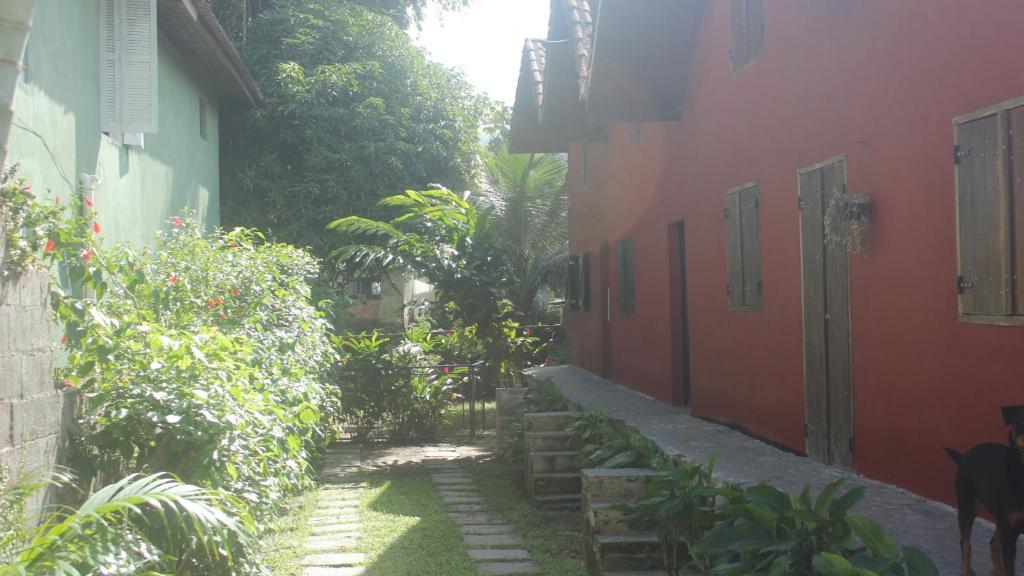 an alley between two buildings with a dog walking down it at Chalés boiçucanga in Boicucanga