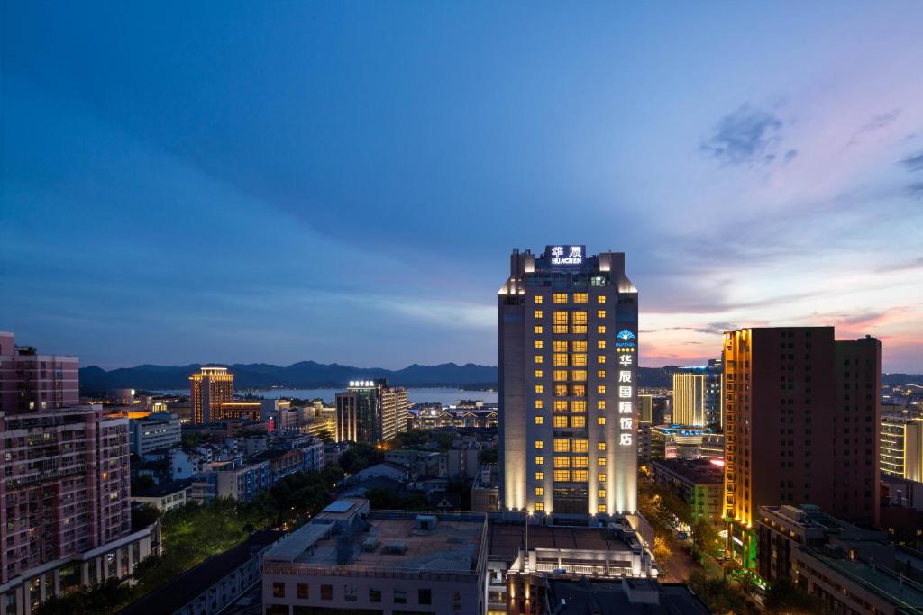 a city skyline at night with a tall building at Huachen International Hotel in Hangzhou