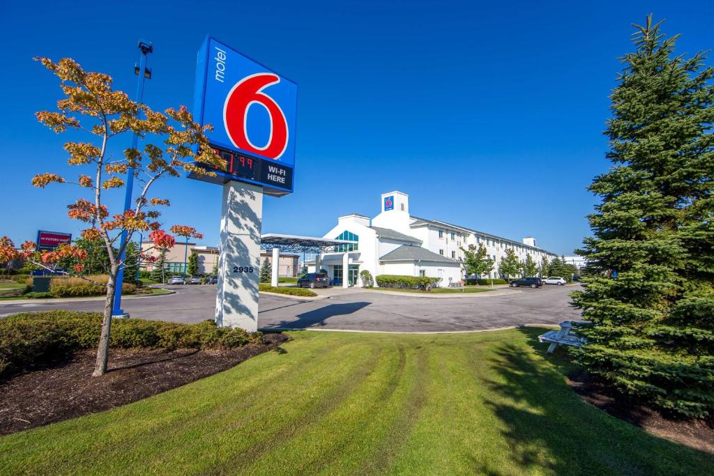 una señal para una gasolinera frente a un edificio en Motel 6-Mississauga, ON - Toronto, en Mississauga