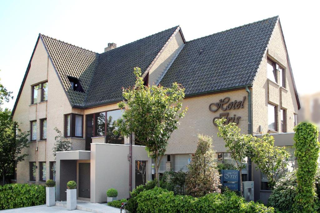 a large house with a black roof at Hotel Iris in De Panne